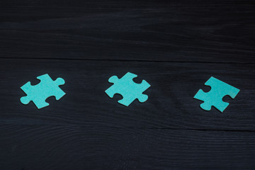 Puzzles on a black wooden background.
