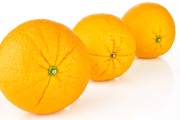 Group of three whole fresh sweet orange placed diagonally isolated on white background