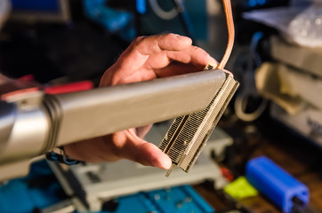 Technical support worker vacuums processor radiator from dust