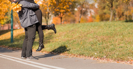 A loving couple - a man and a woman - spend time together in the autumn park, hugging