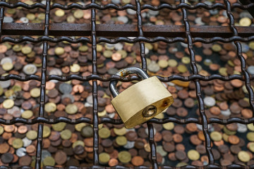 a padlock hanged over coins to making wish