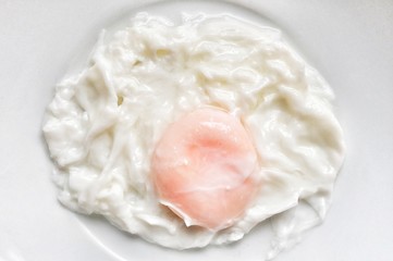 A boiled egg in a plate with white background 