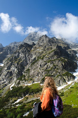 Naklejka premium A young girl loves to travel and conquer the peaks of the mountains