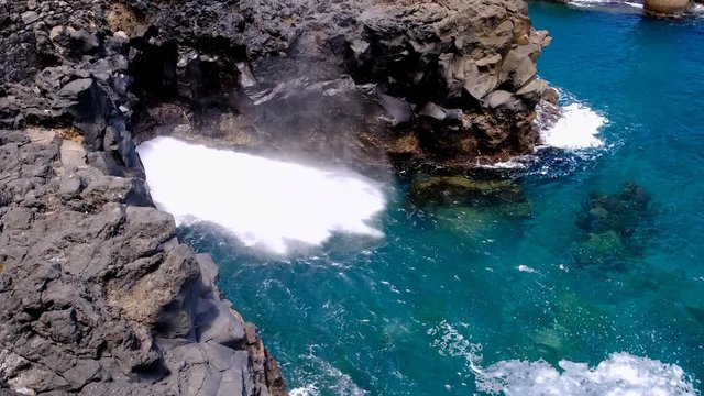 Waves hitting the northern coast of Madeira island in the middle of the Atlantic Ocean with a horizontal blowhole. Slow motion clip at half speed.