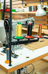 Threads and sewing machine in tailor shop.