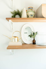 Modern Shelf Decor on Wooden Shelf, Gold Watering Can Decoration, Books, and mirror