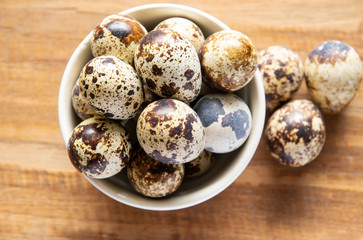Fresh quail egg in bowl on a wooden background
