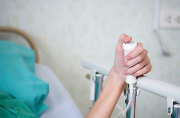 Close up hand of patient press the help button for nurse calling emergency in the hospital