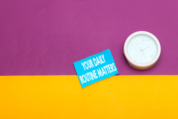 Word writing text Your Daily Routine Matters. Business concept for practice of regularly doing things in fixed order Metal alarm clock wakeup blue notepad colored background.