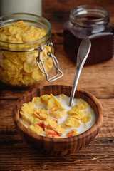 Breakfast with corn flakes, milk and berry syrup