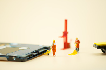 Miniature people: Workers moving circuit board for repair