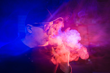 A man smokes an electronic cigarette. The smoke from the vap. Smoking accessories. Electronic...