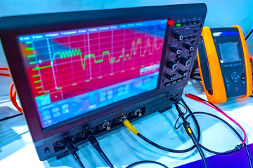Equipment in the laboratory. Control and measuring devices are connected by wires. Graph on the...