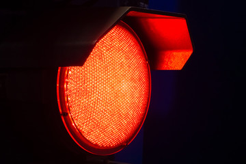 The red light on a dark background. Red traffic light. Forbidding signal. The demand to stop the...