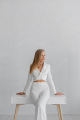 Young beautiful girl in a white business suit