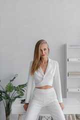 Young beautiful girl in a white business suit