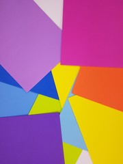 Colorful bright spectrum papers as an abstract background.  Flat lay with geometric shapes.