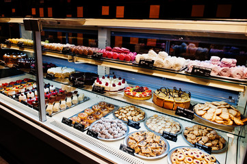 Various cakes on supermarket shelves for sale.