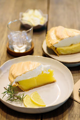 Piece of lemon meringue pie on wooden table