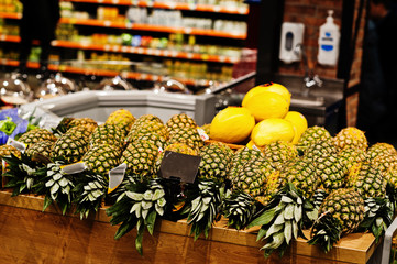 Pineapple on boxes at supermarket for sale.