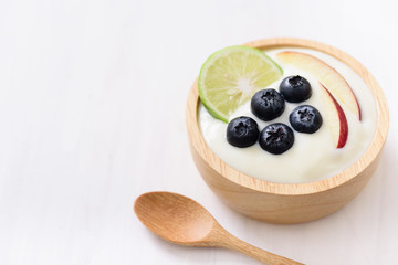 Yoghurt eating with blueberry, apple and lime on white background, healthy food
