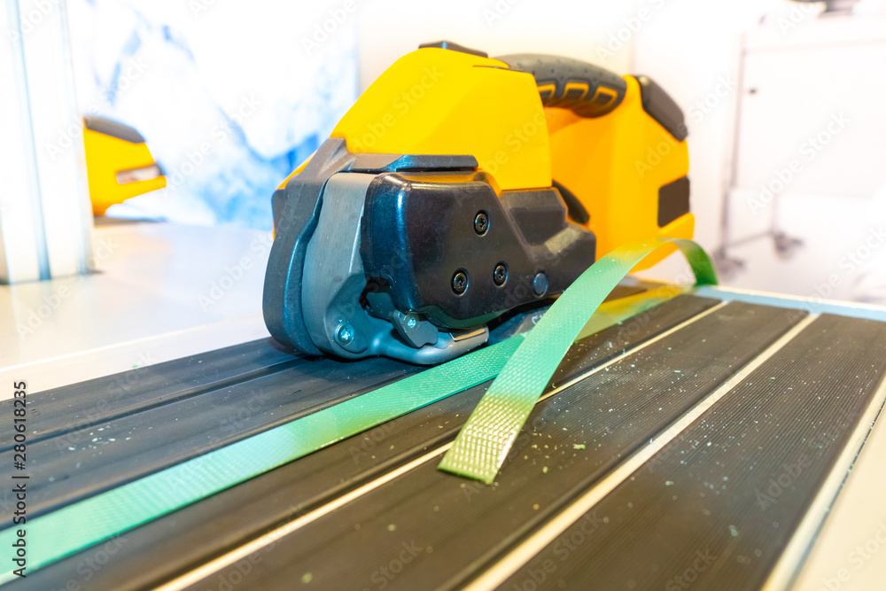 Poster portable strapping machine for packing crates and boxes. packing cargo with strapping tape. packagin