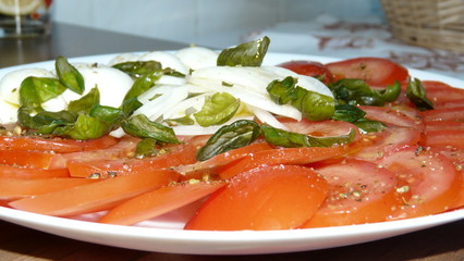 Sliced tomato with buffalo mozzarella onions and olive oil