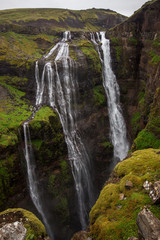 View of Glymur waterfall. Green hills, high waterfall. Iceland