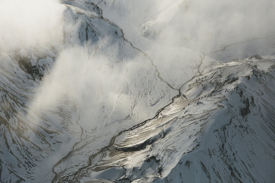 A view looking down into the valley of Landmannalaugar we see a few small rivers connecting below cloud cover.