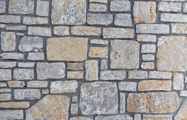 Grey stone wall with interesting texture of stones. Vintage background of grey wall.