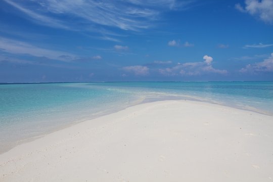 White sand beach  and turquoise sea water of a Maldivian atollo