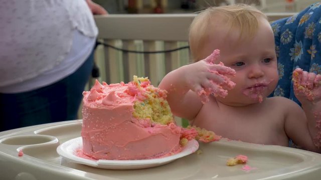 Baby eating cake on her first birthday