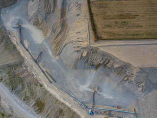 Aerial view of open cast gravel mine in Switzerland. Land grabbing for mining industry. Fields...