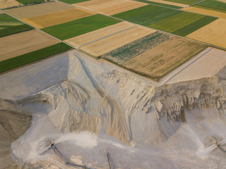 Aerial view of open cast gravel mine in Switzerland. Land grabbing for mining industry. Fields...