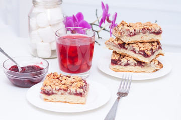 Homemade shortcrust berry pie with crumble on white background. Cherry jam, cherry compote or kissel, tasty cake.