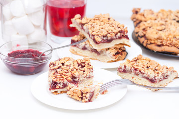 Homemade shortcrust berry pie with crumble on white background. Cherry jam, cherry compote or...
