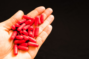 Man's hand holding a handful of medicine pills, to treat addictive diseases