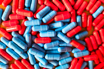 Detail of a handful of mixed red and blue pills.