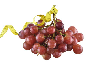 fresh red grapes fruit and tape measure isolated on over white background.