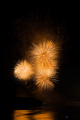 Colorful fireworks. Fireworks are a class of explosive pyrotechnic devices used for aesthetic and entertainment purposes. Visible noise due to low light, soft focus, shallow DOF, slight motion blur