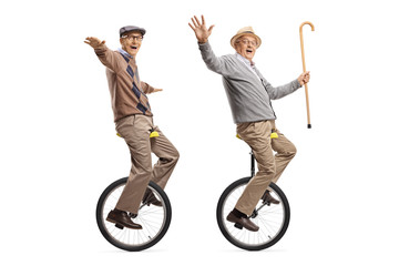 Two cheerful senior men riding unicycles and looking at the camera © Ljupco Smokovski