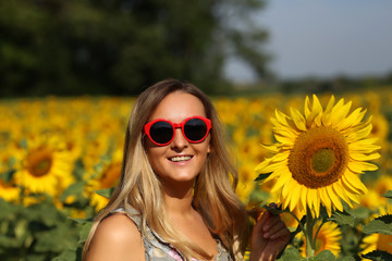 Cute girl in the field full of sunflowers