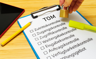 Schild mit der Aufschrift TOM'S (Technisch organisatorische Maßnahmen) in Englisch Technically organizational measures mit einer Tafel und Block zur Signalisierung typischer Tätigkeiten von Datenschut