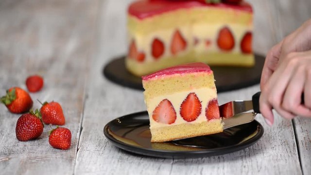 Strawberry cake Fraisier. A piece of strawberry cake in white plate on the wooden table