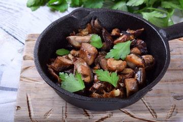 Roasted forest mushrooms topped with fresh parsley in a cast iron pan
