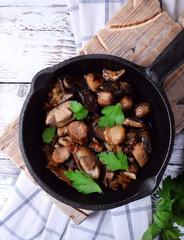 Roasted forest mushrooms topped with fresh parsley in a cast iron pan