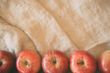 Red apples background in linen background with copy space for design. Top view.