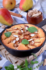 Pie with pears, apples and almonds in a little cast iron pan