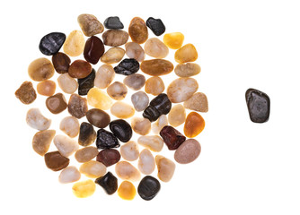 Concept of exclusion and racism made with a group of multi-colored stones (multicolored)....