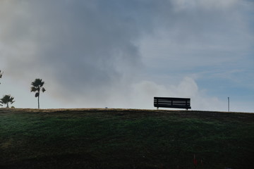 Hill with a bank and clouds behind.